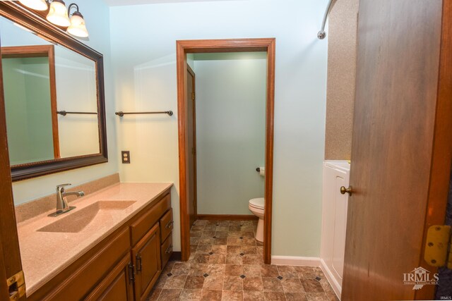 4105 W Friar Dr, Muncie, IN 47304 - bathroom with toilet, vanity, and baseboards