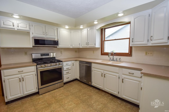4105 W Friar Dr, Muncie, IN 47304 - kitchen featuring appliances with stainless steel finishes, a sink, white cabinetry, light countertops, and a textured ceiling