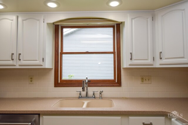 4105 W Friar Dr, Muncie, IN 47304 - kitchen featuring a sink, dishwashing machine, white cabinetry, and light countertops
