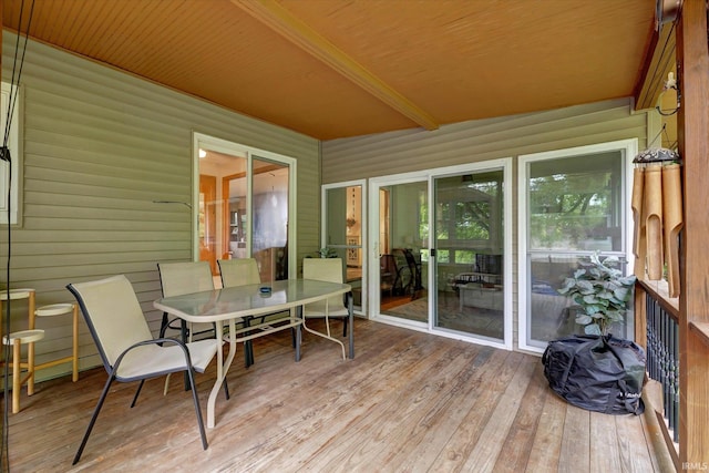 sunroom / solarium with outdoor dining area and beamed ceiling