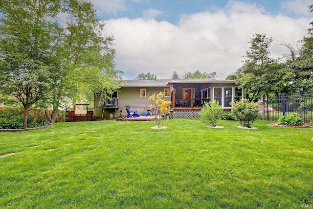 rear view of house featuring a sunroom and a wooden deck