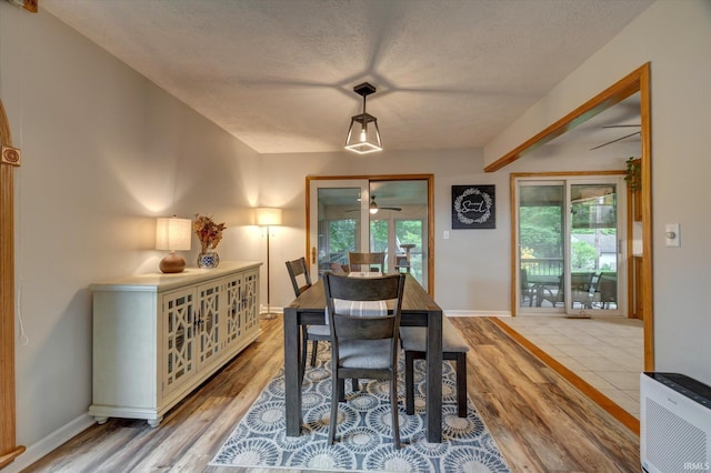 dining space featuring light wood finished floors, a ceiling fan, a textured ceiling, heating unit, and baseboards