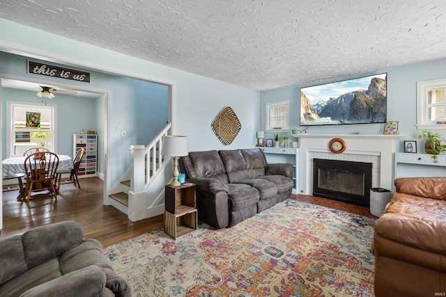 1134 N 14th St, Lafayette, IN 47904 - living room with wood finished floors, a textured ceiling, a brick fireplace, stairway, and a ceiling fan