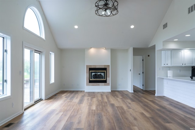 2375 N 110 W, Angola, IN 46703 - unfurnished living room featuring high vaulted ceiling, light wood-type flooring, baseboards, recessed lighting, and a tile fireplace