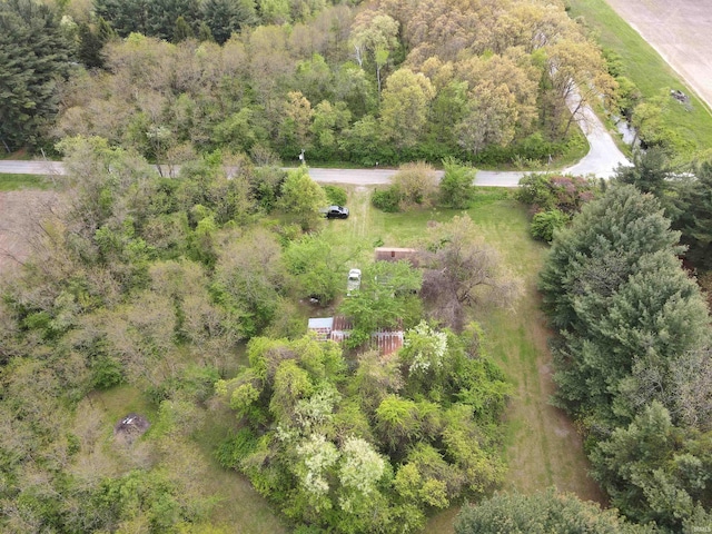 aerial view of property and surrounding area featuring a heavily wooded area