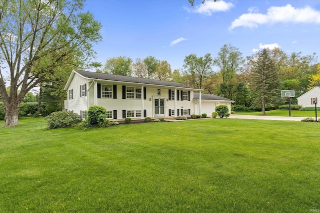 bi-level home featuring driveway, a front yard, and a garage