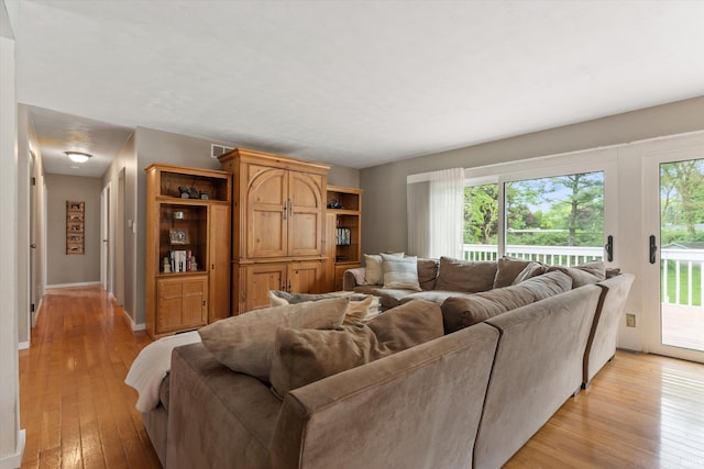 living area with light wood-style flooring and baseboards