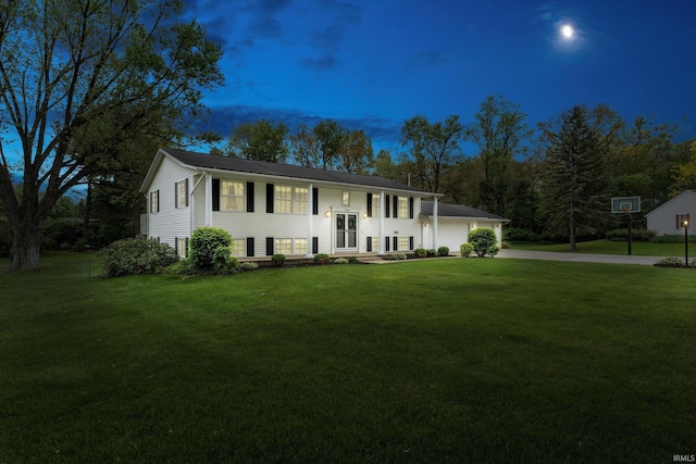 bi-level home featuring driveway, a front yard, and a garage
