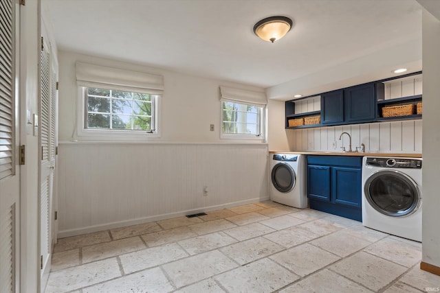 washroom with washer / clothes dryer, stone tile flooring, a wainscoted wall, and baseboards