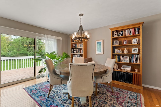 dining space with a chandelier, hardwood / wood-style flooring, and baseboards