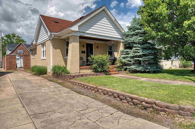 1908 E Mulberry St, Evansville, IN 47714 - view of front of house with brick siding, covered porch, and a front yard