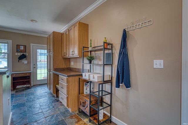 1908 E Mulberry St, Evansville, IN 47714 - kitchen with stone tile flooring, ornamental molding, dark countertops, brown cabinetry, and baseboards