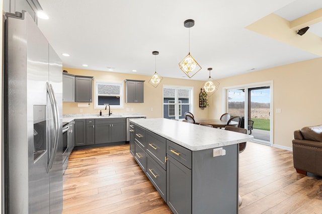 kitchen featuring stainless steel fridge, a sink, gray cabinets, light countertops, and recessed lighting