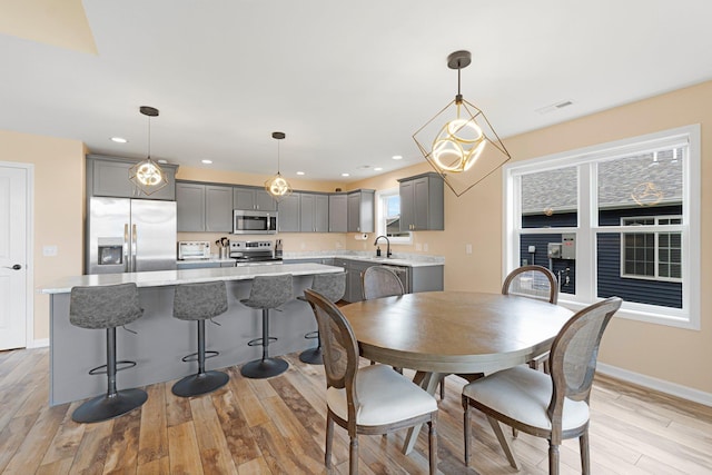 dining room featuring light wood-style flooring, baseboards, and recessed lighting