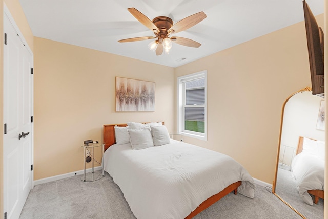 bedroom with light carpet, baseboards, and a ceiling fan