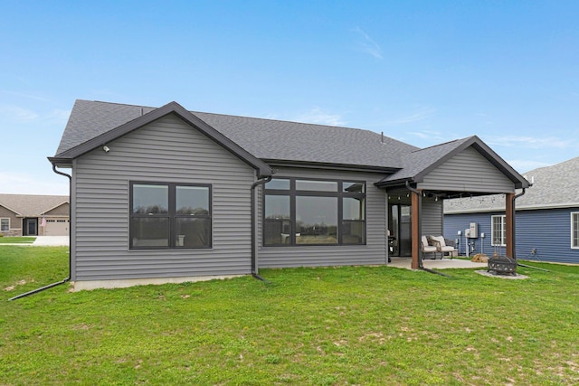 back of property featuring a yard, an outdoor fire pit, a patio area, and a shingled roof
