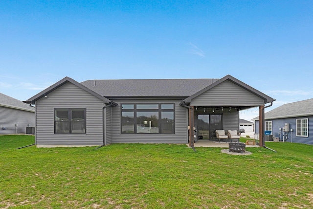 rear view of house featuring a yard, central AC unit, a fire pit, and a patio area