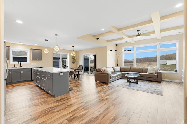 kitchen featuring gray cabinetry, light wood-style floors, light countertops, coffered ceiling, and beamed ceiling