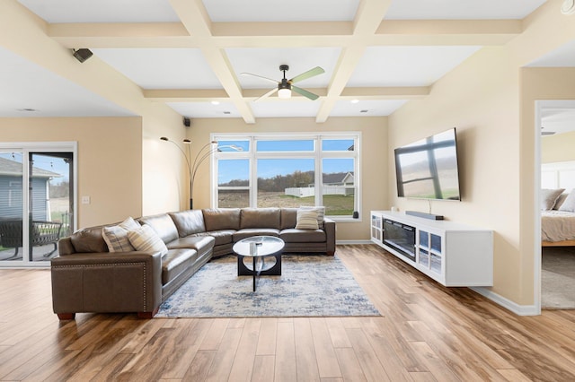 living area with ceiling fan, light wood-style flooring, beamed ceiling, coffered ceiling, and baseboards