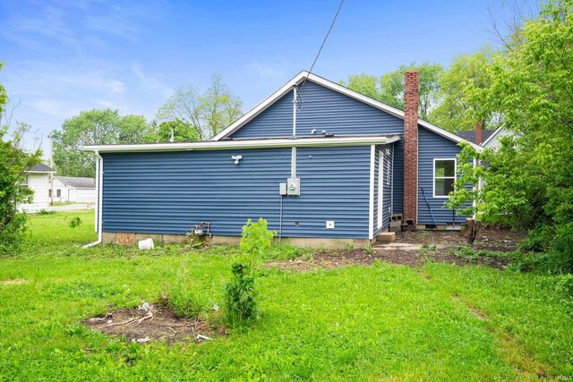 615 W Kickapoo St, Hartford City, IN 47348 - back of house featuring a lawn and a chimney