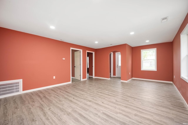 615 W Kickapoo St, Hartford City, IN 47348 - unfurnished living room with arched walkways, light wood finished floors, baseboards, and recessed lighting