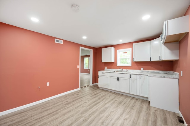 615 W Kickapoo St, Hartford City, IN 47348 - kitchen featuring light wood-style floors, a sink, white cabinets, light countertops, and recessed lighting