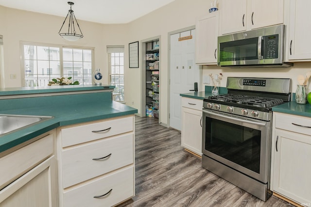 3630 E Tamarron Dr, Bloomington, IN 47408 - kitchen with appliances with stainless steel finishes, dark countertops, dark wood-style floors, and hanging light fixtures