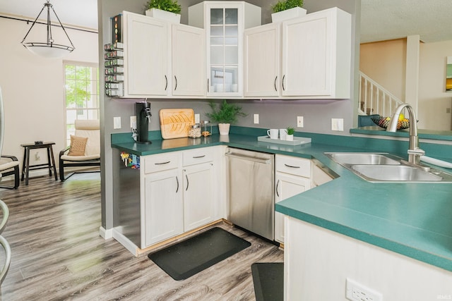 3630 E Tamarron Dr, Bloomington, IN 47408 - kitchen with a sink, stainless steel dishwasher, light wood-type flooring, white cabinets, and glass insert cabinets