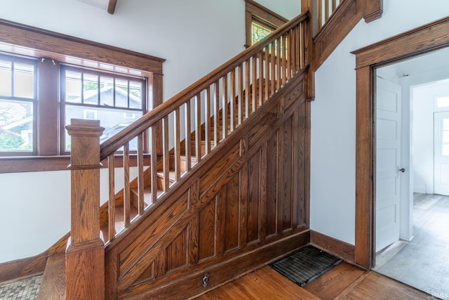 staircase featuring wood finished floors and baseboards