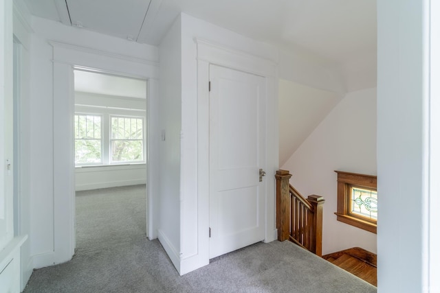 hall with an upstairs landing, attic access, and carpet