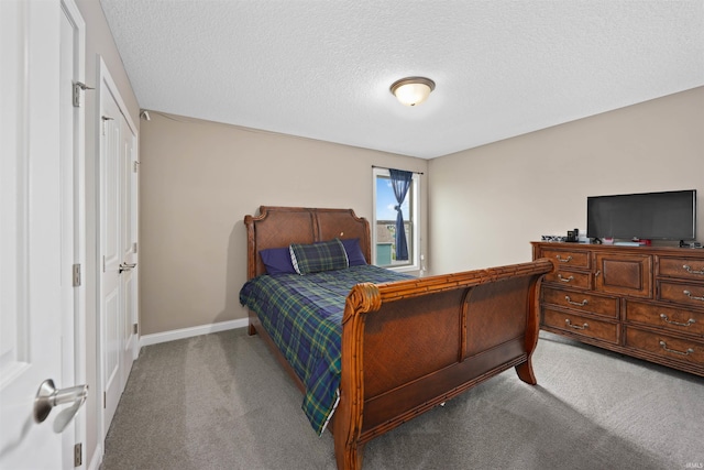 carpeted bedroom with a textured ceiling and baseboards
