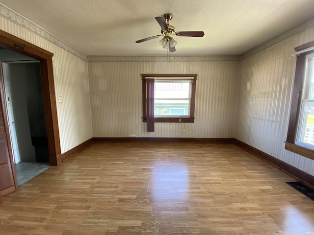 1107 S St, Bedford, IN 47421 - unfurnished room featuring wood finished floors, plenty of natural light, baseboards, wallpapered walls, and a textured ceiling