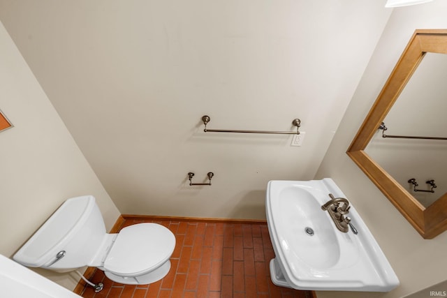 227 N Twyckenham Dr, South Bend, IN 46617 - bathroom featuring brick flooring, a sink, toilet, and baseboards
