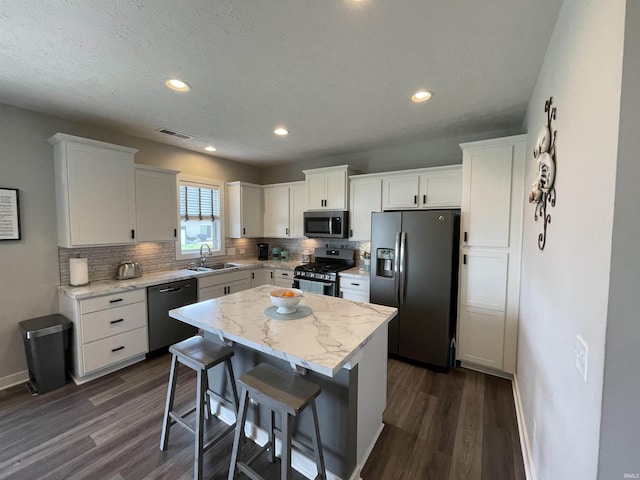 2327 Jamaica Ct, Evansville, IN 47725 - kitchen with appliances with stainless steel finishes, a sink, dark wood finished floors, decorative backsplash, and baseboards