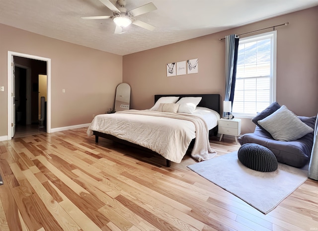 bedroom featuring light wood-style flooring, ceiling fan, and baseboards