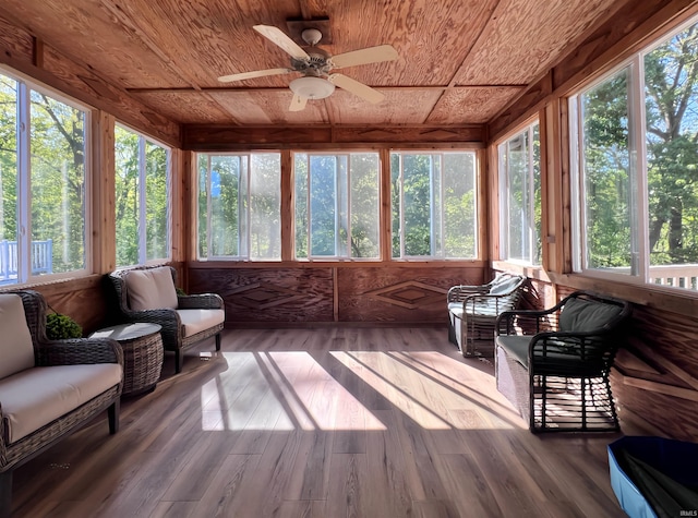sunroom / solarium featuring wood ceiling, healthy amount of natural light, wood finished floors, and a deck