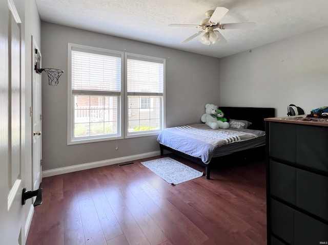 bedroom with baseboards, dark wood-style flooring, and a ceiling fan