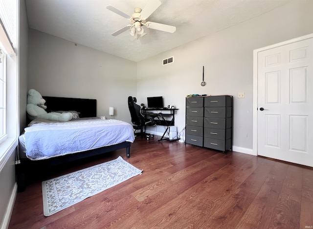 bedroom featuring wood finished floors, baseboards, a ceiling fan, and an office area