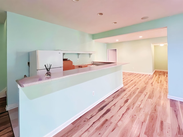 kitchen featuring freestanding refrigerator, light wood-type flooring, baseboards, and recessed lighting