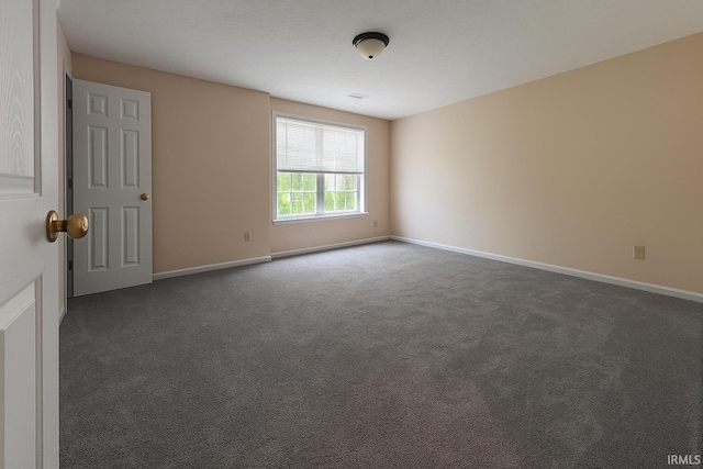 spare room featuring baseboards and carpet