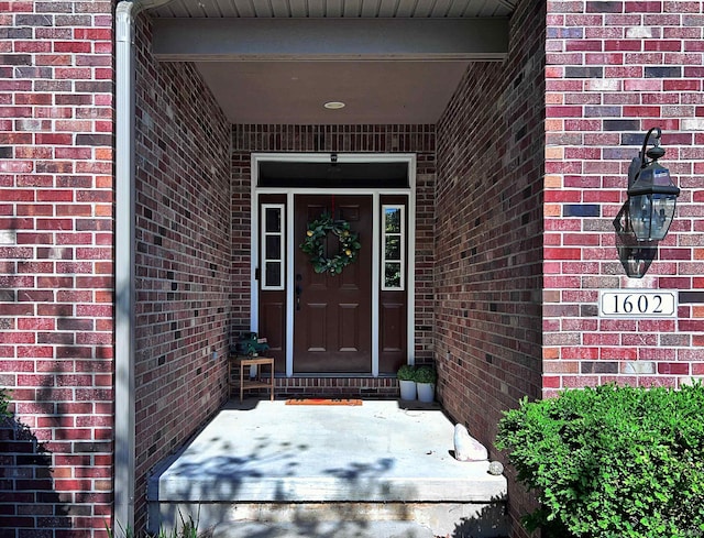 property entrance featuring brick siding
