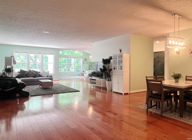 living room featuring a textured ceiling, hardwood / wood-style floors, and baseboards