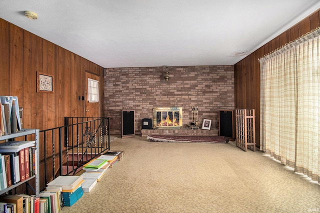 unfurnished living room with wooden walls, a fireplace, and carpet flooring