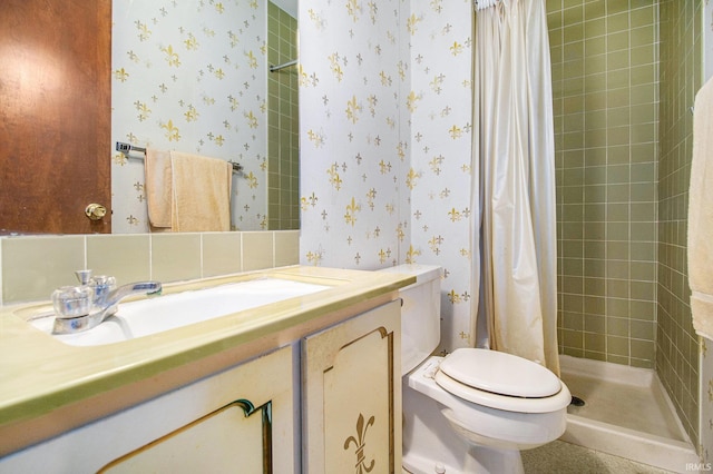 full bath with wallpapered walls, a stall shower, vanity, and toilet