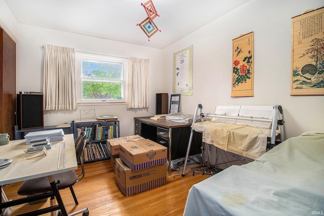 bedroom with light wood-style flooring and a desk