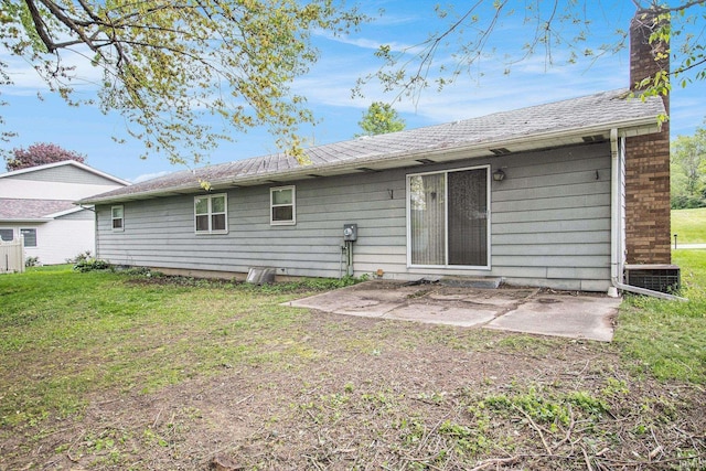 rear view of property with a patio area, a chimney, and a lawn