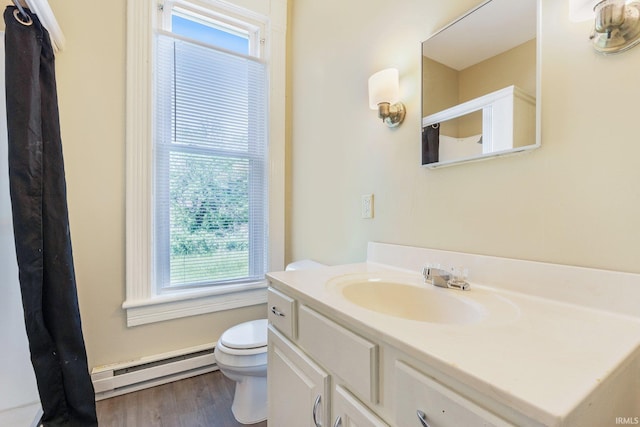 bathroom featuring a baseboard radiator, toilet, vanity, and wood finished floors