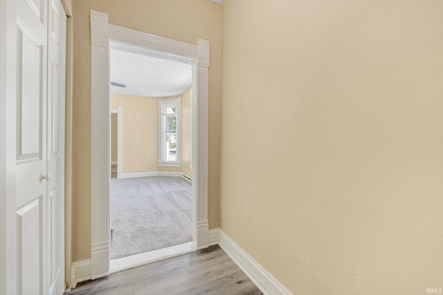 hall with baseboards and light wood-style flooring