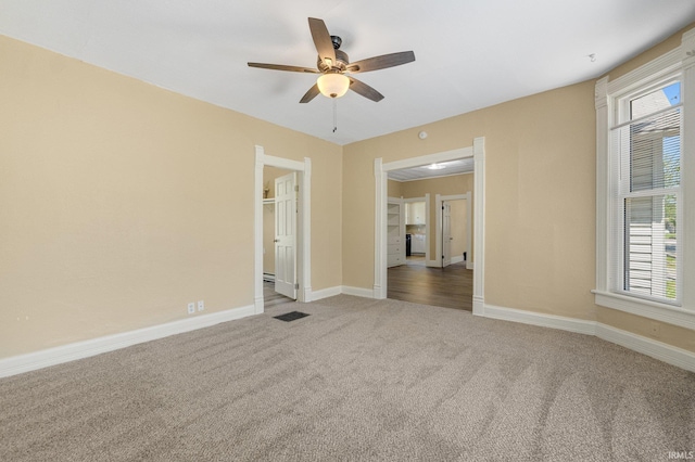 spare room featuring carpet, a ceiling fan, and baseboards