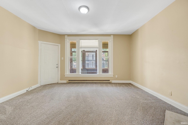 carpeted spare room with baseboard heating and baseboards